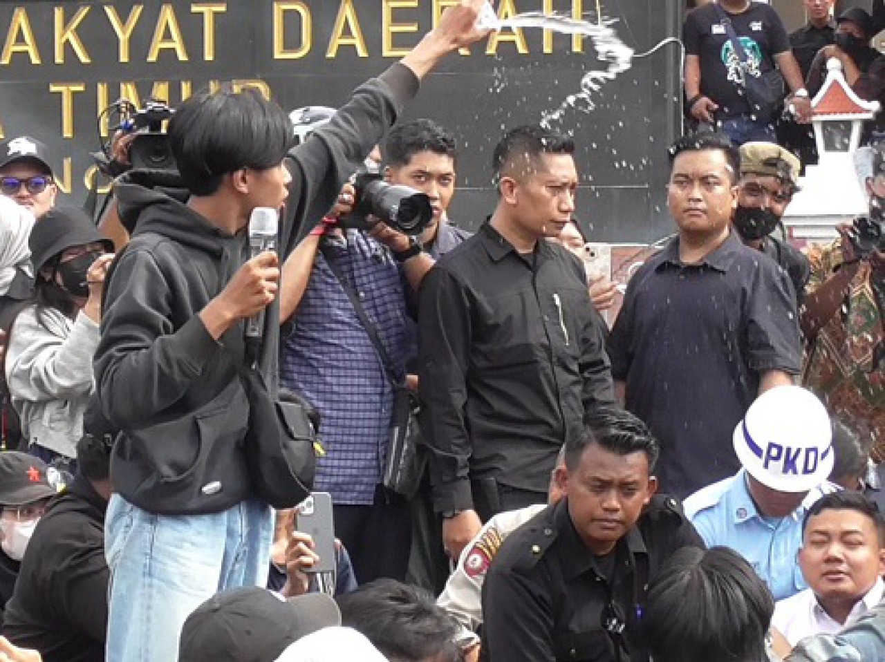 Salah satu demonstran Indonesia Gelap menyiram Yordan dan Fuad dengan air kemasan, Jumat, (21/02/2025).