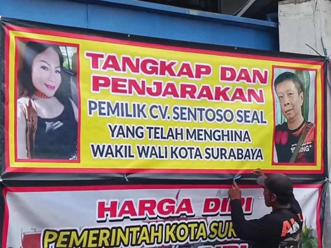 Gerakan Arek Suroboyo Bersatu memasang spanduk penyegelan Gudang UD Sentosa Seal, Selasa, (15/04/2025).