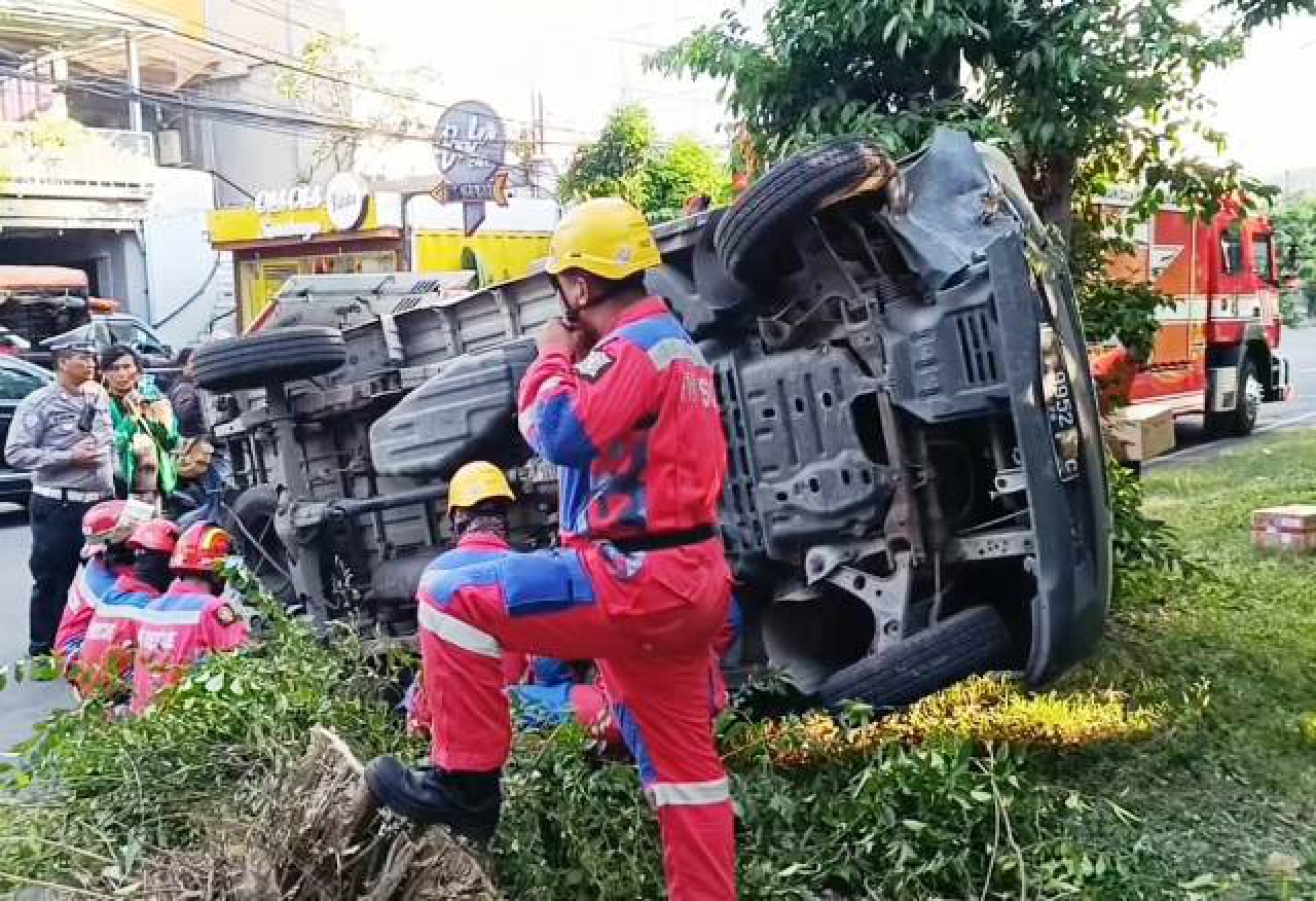 Mobil box nomor polisi L-9952-C terguling.