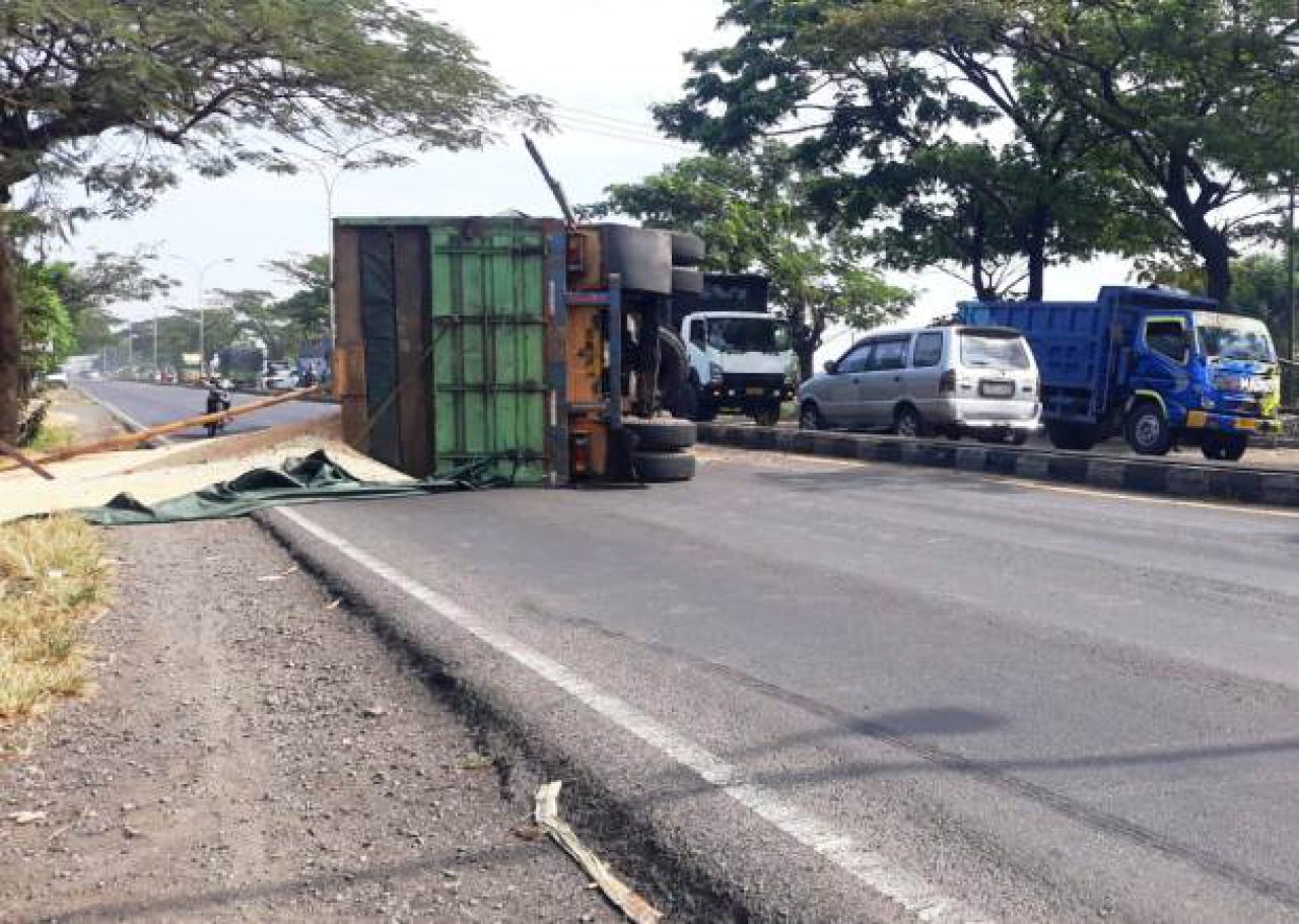 Truk nomor polisi W-9628-UM terguling.