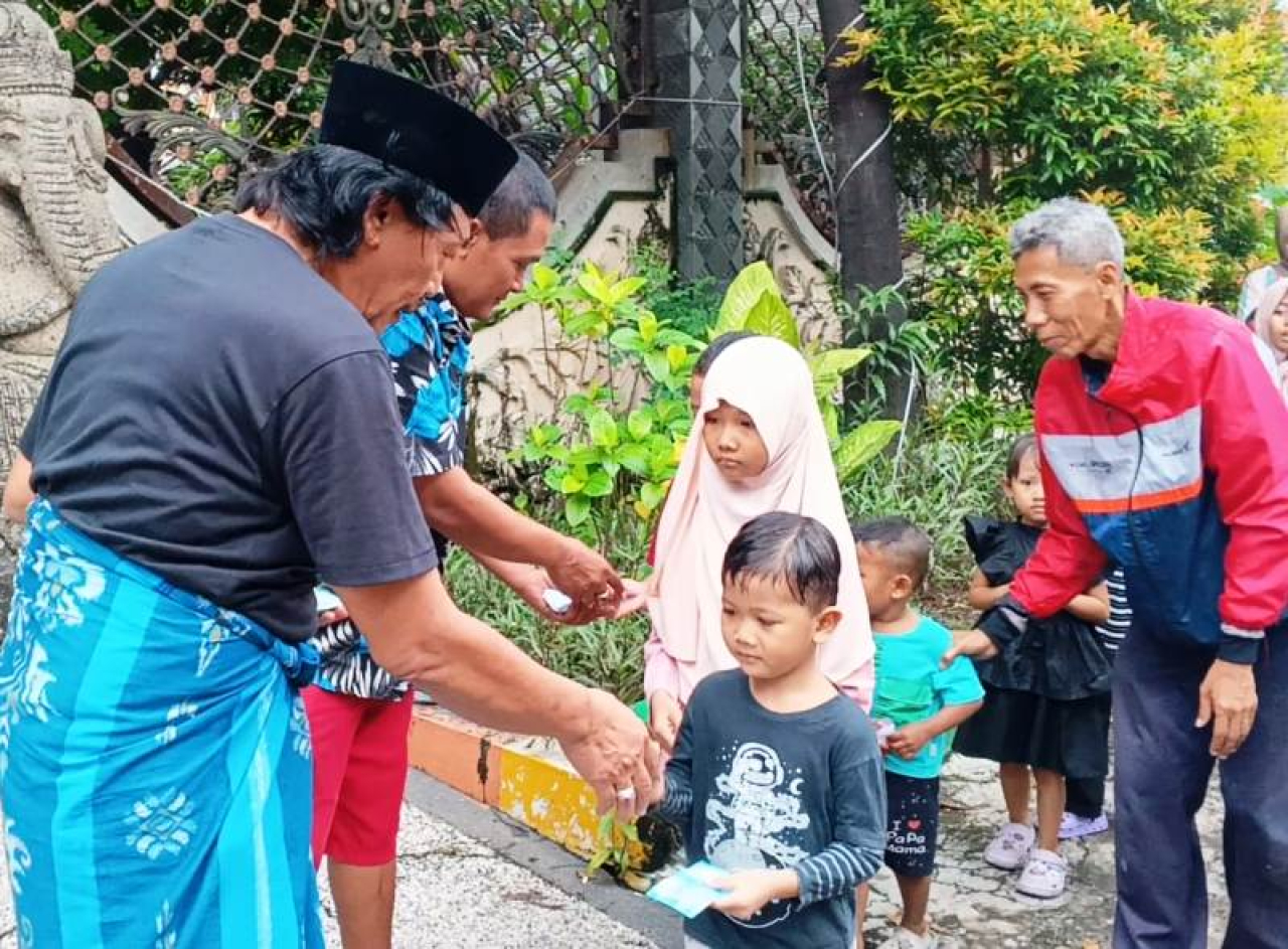 Heru Sangoko saat membagikan uang lebaran kepada anak-anak