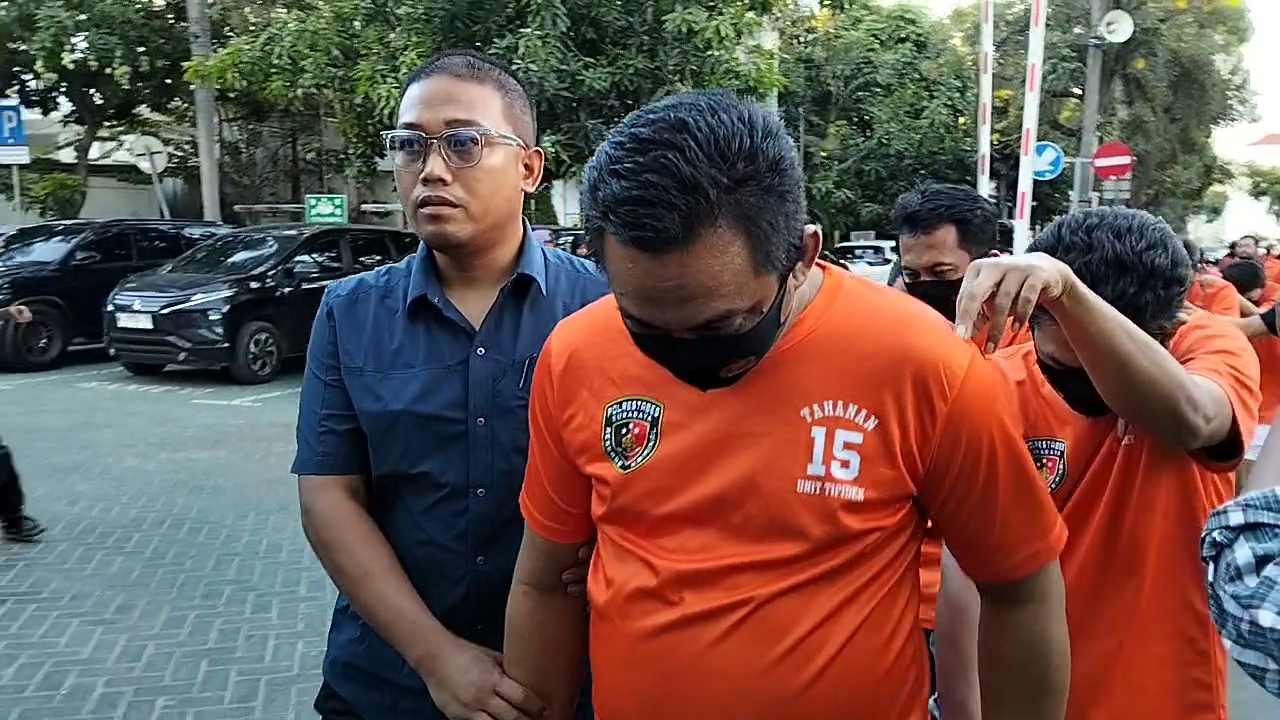 Anggota Polrestabes Surabaya menggiring 14 tersangka joki UTBK 2026 UNESA ke gedung tahanan, Kamis, (17/04/2026).