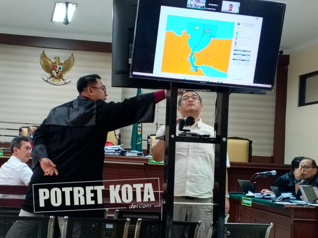 Yosef Haruman Merdi Ratu menunjuk peta kolam pelabuhan.