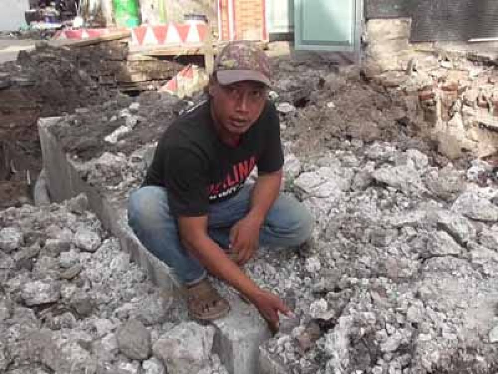 Arif Sugiarto, warga Kapas Baru, Surabaya, menunjukkan bagian box culvert yang dipasang renggang antara 10 hingga 20 sentimeter, Selasa, (30/04/2024).