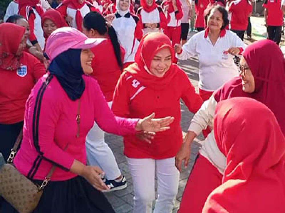 Nurul Qomariyah (memakai topi merah muda) owner Bunda Nurul Fried Chicken ikut bergoyang bersama warga RT 06 Gadukan, Surabaya, memeriahkan Peringatan HUT ke-77 Kemerdekaan RI, Rabu, (17/08/2022).