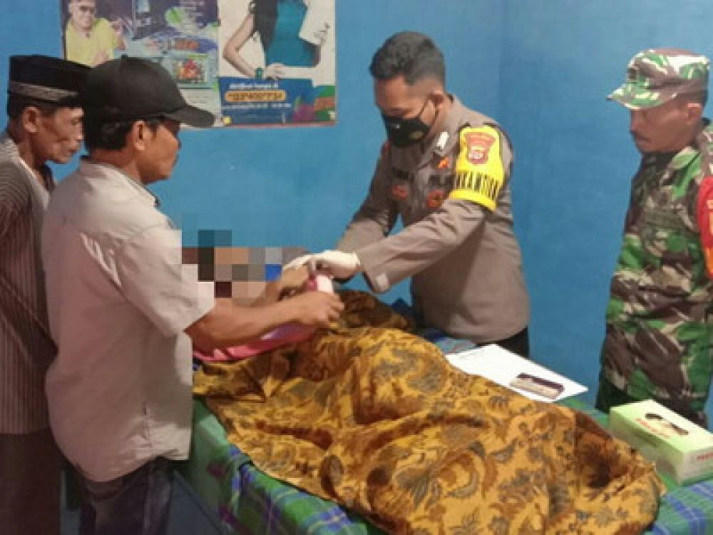 Petugas Polsek Gading Rejo memeriksa jenazah salah satu dari dua bocah yang ditemukan dengan kondisi sudah meninggal dunia diduga tenggelam di aliran sungai Klaten, Gading Rejo, Kabupaten Pringsewu, Provinsi Lampung, Kamis, 30 Juni 2022.