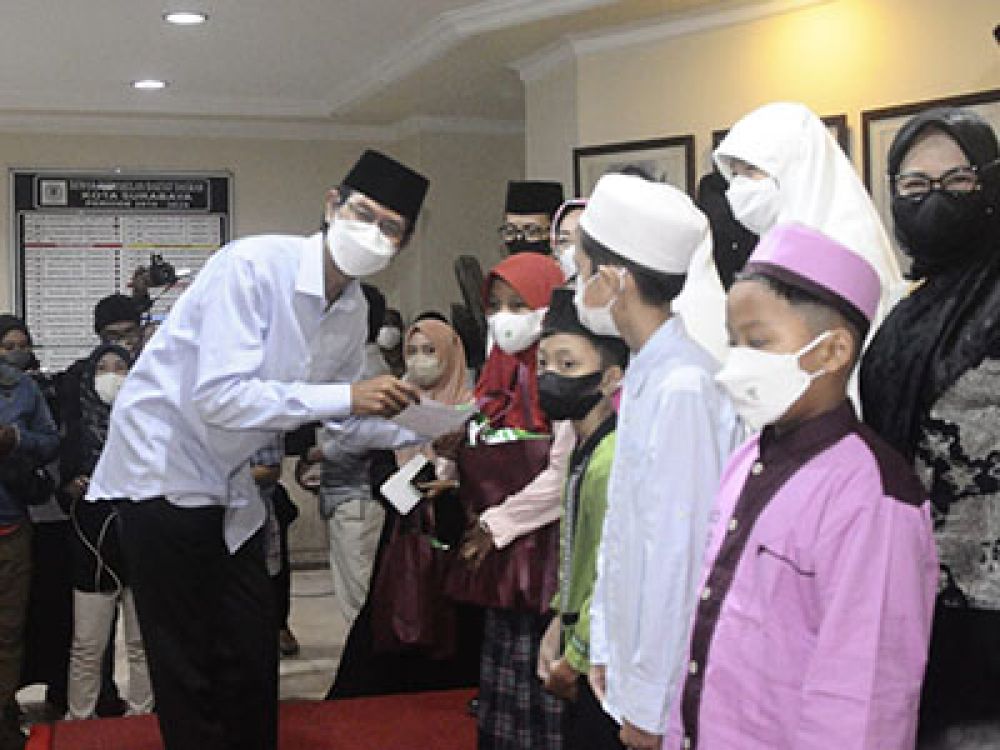Pemberian satuan secara simbolis kepada anak yatim piatu oleh Ketua DPRD Kota Surabaya Adi Sutarwijono.