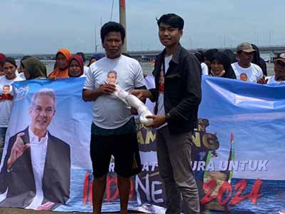 Salah satu relawan Ganjar di Madura saat menyalurkan peralatan melaut ke pada nelayan di Tambak Wedi, Surabaya.