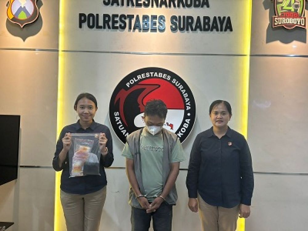 Tersangka IM (tengah) diapit dua petugas Sat Res Narkoba Polrestabes Surabaya, Senin, (12/02/2024).