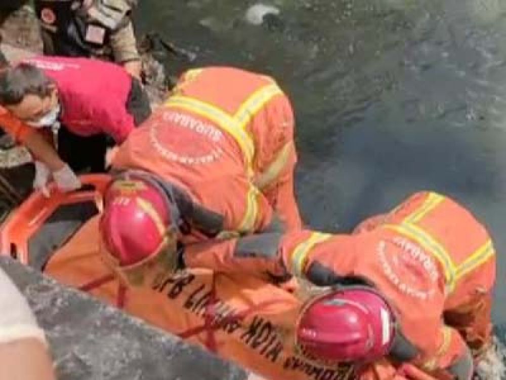 Petugas PMK saat mengevakuasi korban dari sungai.