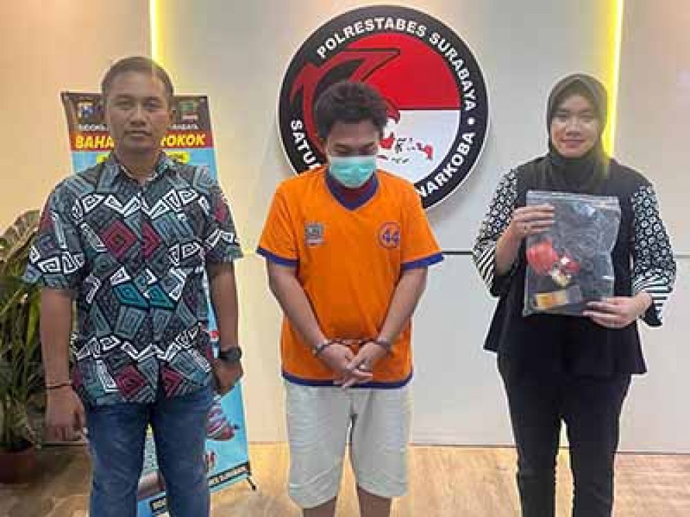 Tersangka FF diapit dua petugas Satresnarkoba Polrestabes Surabaya.