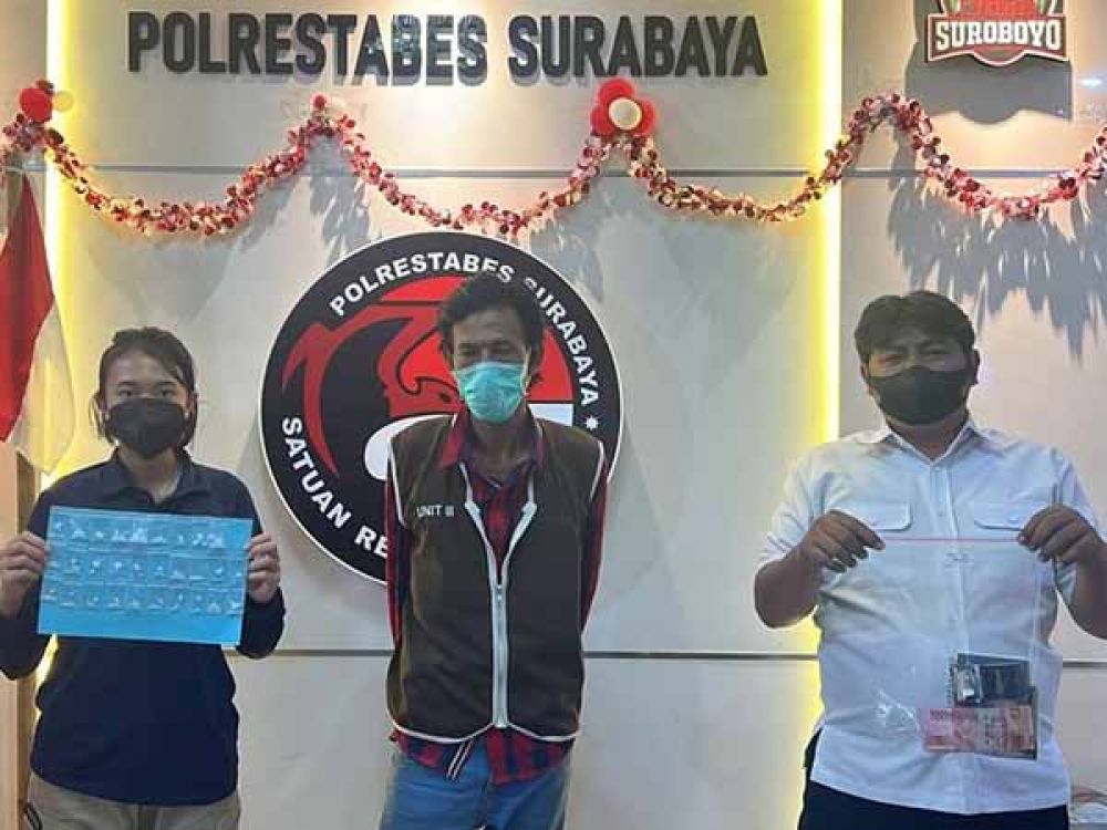 Tersangka AP diapit dua petugas Sat Resnarkoba Polrestabes Surabaya berikut barang bukti.