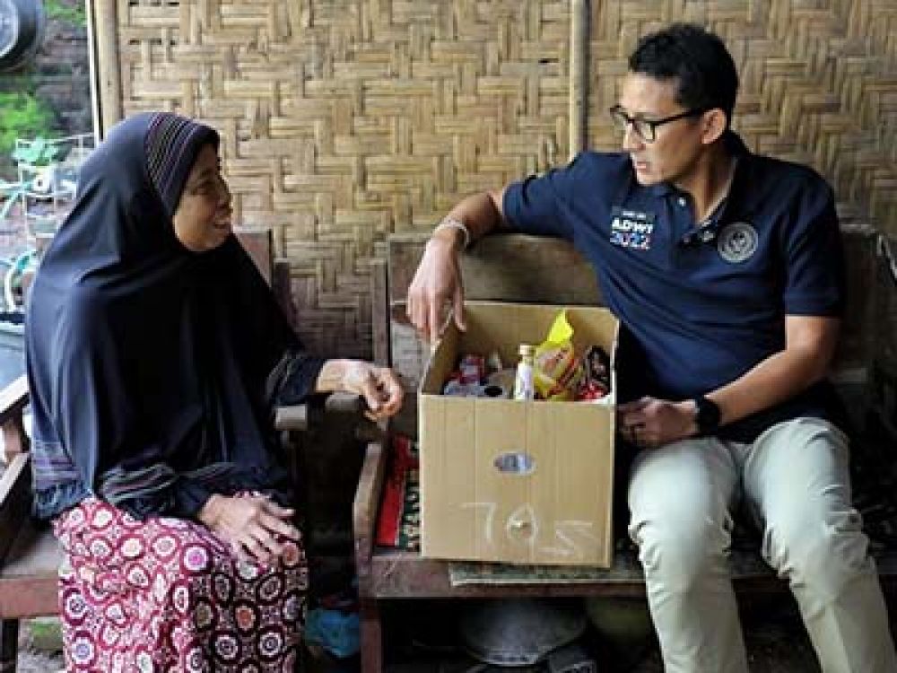 Sandiaga Uno berbincang dengan nenek Painah dan menyerahkan bantuan.