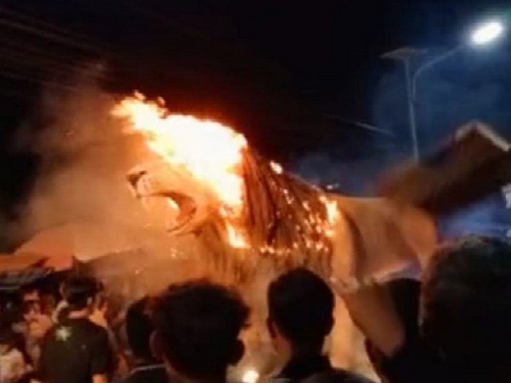 Patung Singa Sidodadi saat terbakar ketika karnaval Agustusan di Desa Sembayat, Gresik berlangsung, Rabu malam, (17/08/2022).