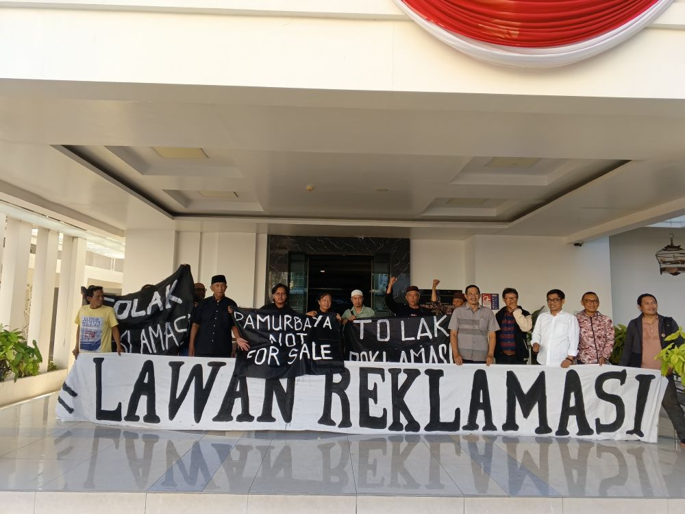 AMPS membentangkan spanduk tolak reklamasi di Kantor DPRD Surabaya, Senin (19/8/2024).
