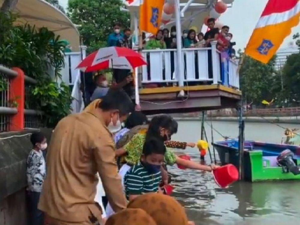 Murid SDN Kaliasin I Surabaya saat menebar benih ikan.