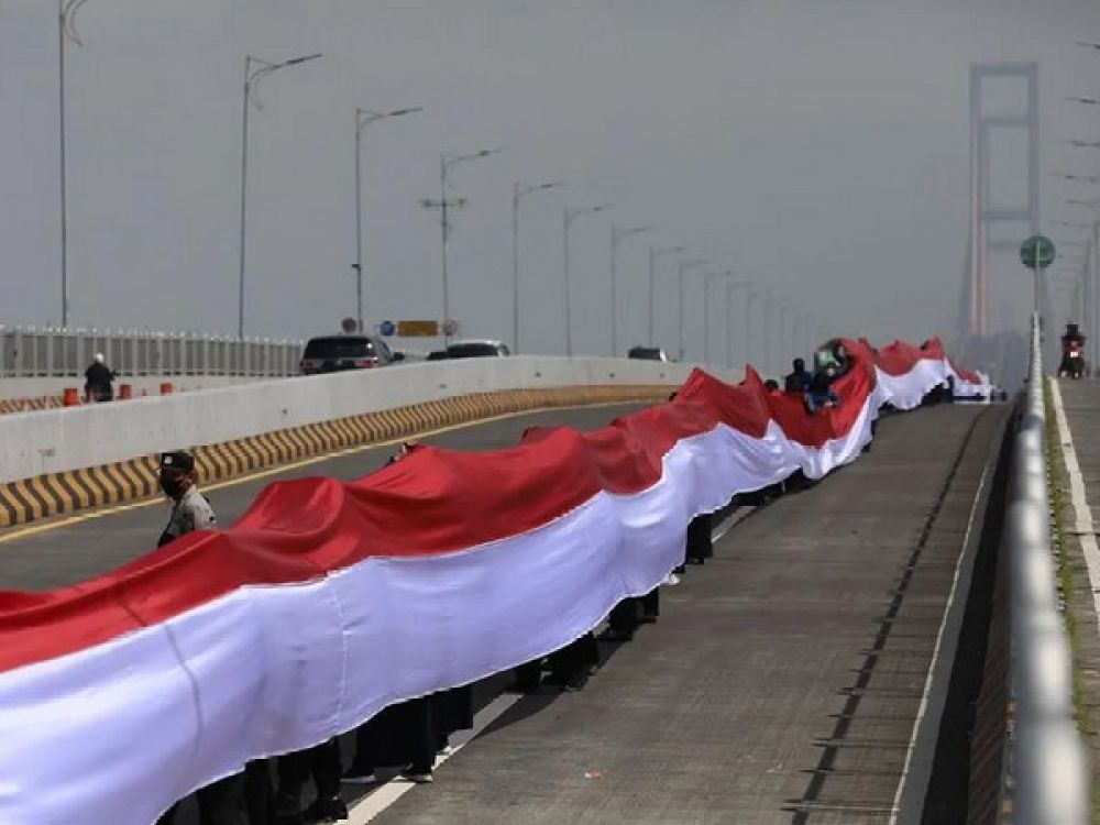 Proses bentang bendera merah putih sepanjang 3219 meter di Jembatan Suramadu, Kamis, (10/11/2022).